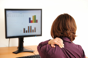 Cervikální osteochondróza u ženy sedící u počítače